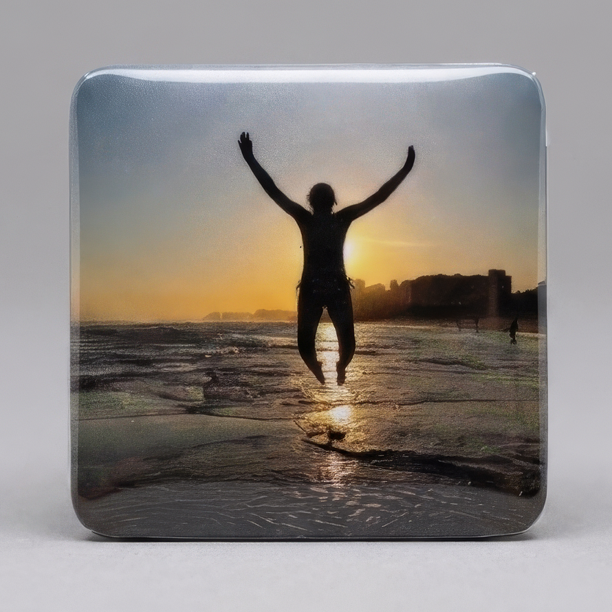 Ímã com foto de silhueta pulando na praia ao pôr do sol com braços erguidos